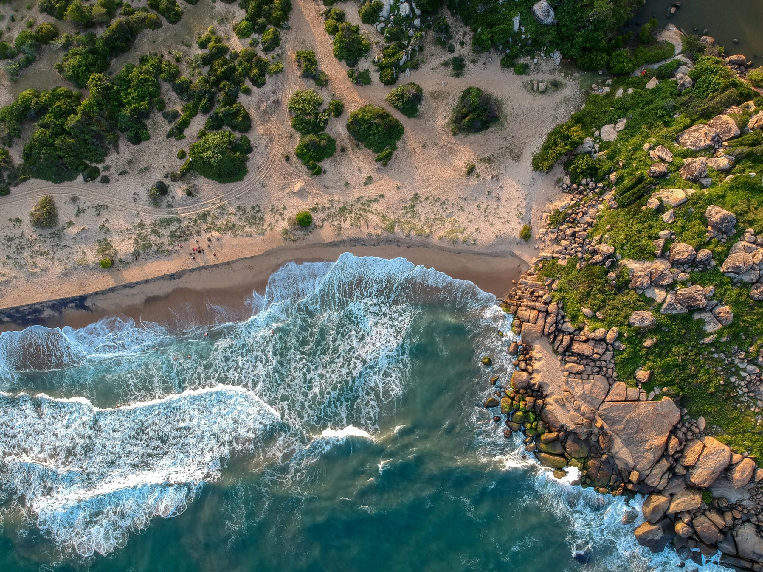 Breathtaking aerial view of lush green coastline in Sri Lanka with rocky cliffs and waves.